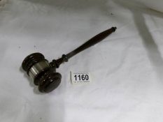 A wooden gavel with silver collar