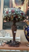 A tall table lamp with Tiffany style glass shade