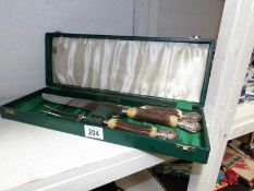 A cased carving set with silver plate and horn handles by Cooper Brothers,