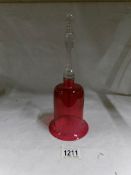 A Victorian cranberry glass bell (missing clanger)