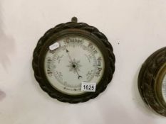 An oak rope edge barometer with porcelain face