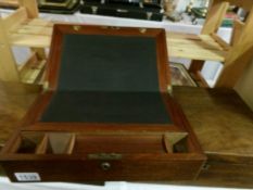 A mahogany writing box with brass oval in lid