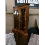 A mahogany 'concave' front astragal glazed corner cabinet