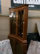 A mahogany 'concave' front astragal glazed corner cabinet