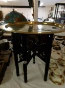 A folding table with brass tray top