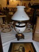 A Victorian oil lamp with ceramic base and complete with shade and chimney