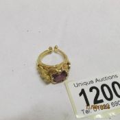 An 18ct gold ring with nude figure on shoulder and set amethyst,