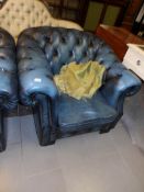 A blue leather chesterfield chair