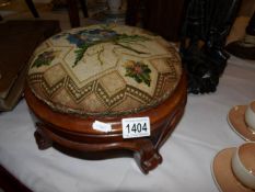 A mahognay footstool with tapestry cover