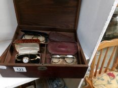 A wooden box containing vintage spectacles