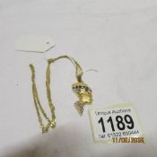A 9ct gold chain and Tut-ank-amen head pendant set sapphires