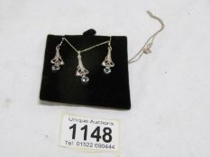 A silver pendant and matching earrings