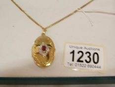 A 9ct gold locket set ruby on chain