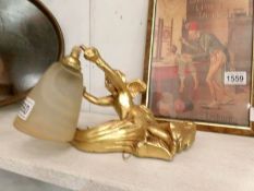 A gilded cherub wall light with shade