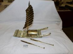 A brass sailing raft with oars