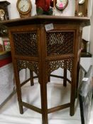 A Victorian ornately carved Burmese table with brass inlay