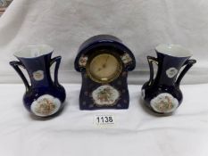 A small 3 piece ceramic clock garniture depicting cherubs