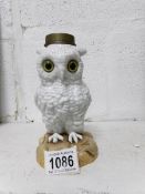 A 19th century novelty porcelain oil lamp base in the shape of an white owl with glass eyes