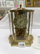 A brass cased Kundo anniversary clock with instructions
