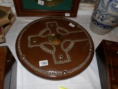 A circular brass studded shield