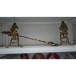 A pair of ornate fire dogs and fire irons