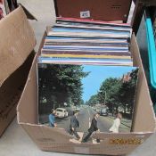 A box of LP records including Beatles, Bowie, Genesis,