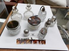 A silver topped perfume bottle, silver backed comb, lidded pots,