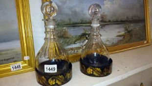 A pair of 19th century glass decanters on lacquered coasters