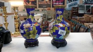 A pair of cloissonne vases on stands