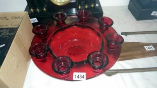 A red glass candle holder featuring removable stems and central bowl
