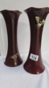 A pair of pottery vases decorated moths