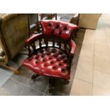 A deep red leather captain's chair (small piece of wood missing underneath