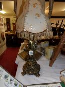 A gilded spelter cherub table lamp with shade