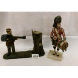 A mechanical money box and a Scots guard figure