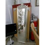 A tall mirror in silver coloured frame
