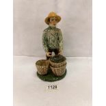 A Coll pottery (Isle of Lewis) figure of a fisherman with baskets