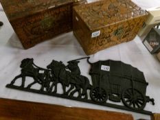 A cast metal horse and cart wall plaque
