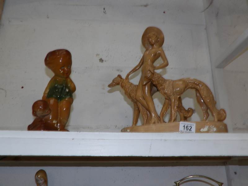 An Art Deco plaster figurine with dogs and a plaster figure of a boy