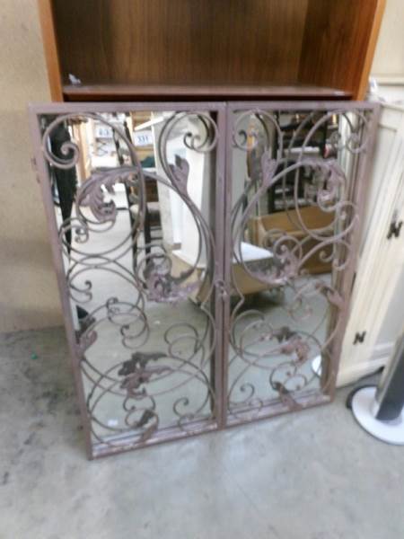 A wrought iron framed mirror
