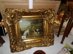 An overpainted picture of gun dogs with parrot in an ornate gilt frame