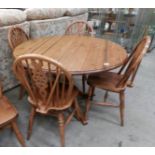 A pine circular table and 4 chairs