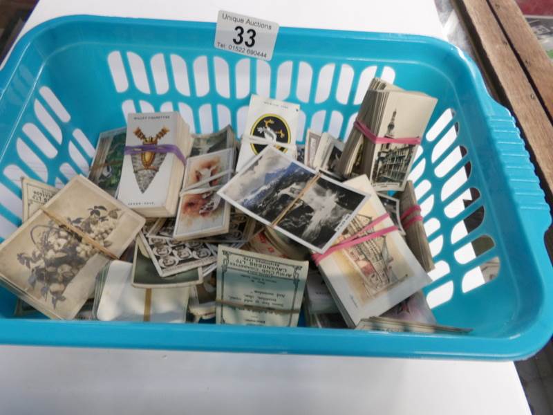 A basket of cigarette cards including De Reskze, Will's, Players,