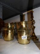 A pair of Victorian brass candlesticks and a pair of brass jugs