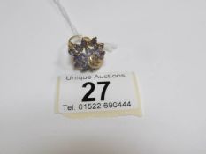 A 9ct gold ring set tanzanite in a floral spray,