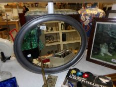 An oval framed bevel edged mirror
