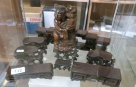 A quantity of Oriental wooden stands and a figure