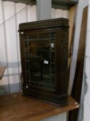 A late 19th century carved oak hanging corner cabinet