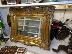 An ornate gilt framed bevel edged mirror