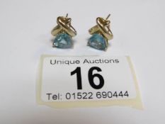 A pair of 9ct gold earrings with 'trillion' cut blue topaz stones