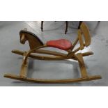 Pine baby’s rocking horse with red seat, 33”w x 20”h.